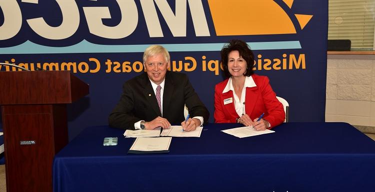 Dr. Mary Graham, Mississippi Gulf Coast Community College president, left, and Dr. Tony Waldrop, USA president, sign a commitment for the Pathway USA program.